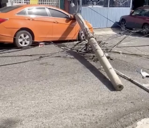 Cae poste eléctrico sobre carro tras camión de basura arrastrar cables en SDO