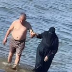 Pareja musulmana llama la atención en la playa